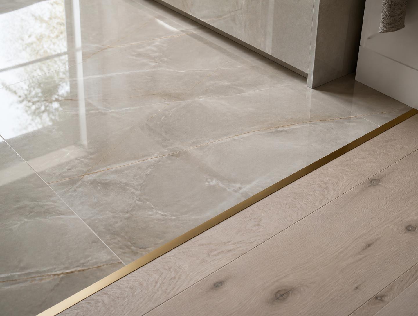 Detail of large-format stone-look porcelain meeting wide-plank white oak